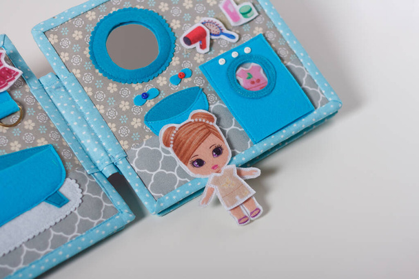 Educational felt book with small wooly details and buttons for little children. Girl in bathroom with bathtube, mirror, sink. Leisure and early preschool development, distant home education concept. - Photo, Image
