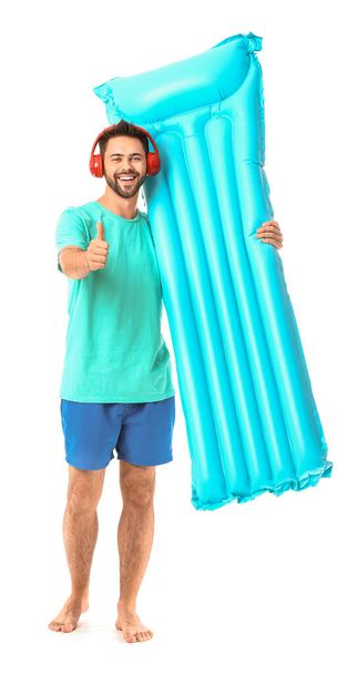 Happy man with headphones and inflatable mattress on white background - Foto, Imagem