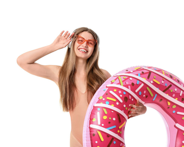 Young woman with headphones and inflatable ring on white background - Fotografie, Obrázek