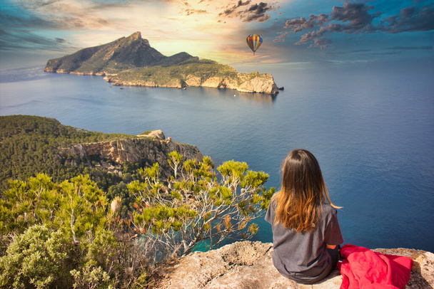 belle fille asiatique avec des vêtements de sport gris et veste d'hiver rouge monte dans la montagne pour profiter de la vue sur ce paysage phénoménal dans les îles Baléares - Photo, image