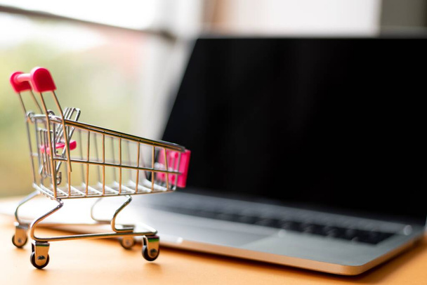 Close-Up Of Laptop And Shopping Cart By Credit Card On Table - Photo, Image