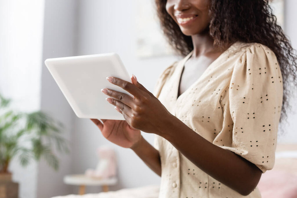 cropped view of african american woman in blouse using digital tablet at home - Photo, Image