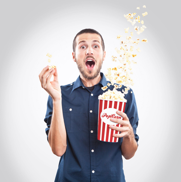Young man watching a movie with popcorn - Φωτογραφία, εικόνα