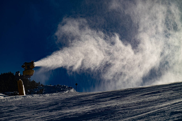 Esquiadores y snowboarders montando fuelle de nieve de trabajo. Nube nevada pesada flota en la pista en Italia estación de esquí. - Foto, Imagen