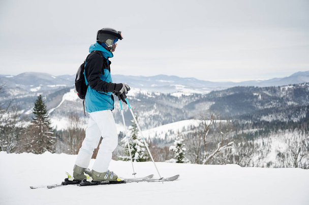 Skifahrer mit Blick auf die schneebedeckten Berge im Skigebiet. Konzept der Wintersportaktivitäten. - Foto, Bild