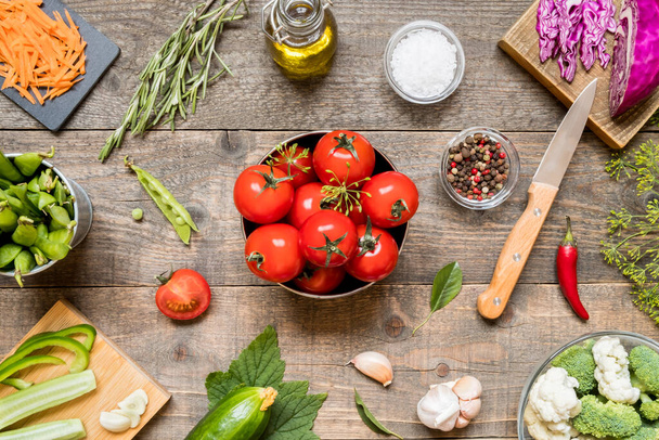 Top view of various raw ingredients for canning vegetables and seasonings on a dark wooden background. Vegan ingredients for cooking - Foto, afbeelding