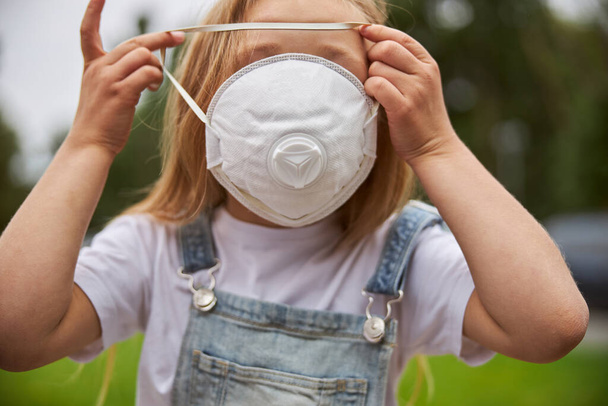 Милая девочка в защитной маске на лице - Фото, изображение