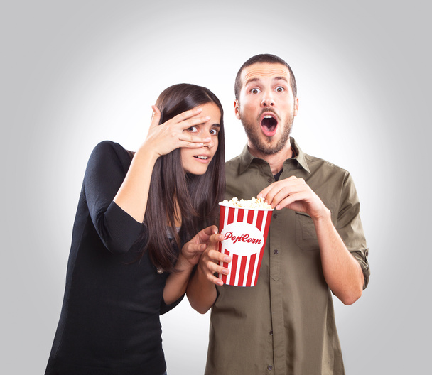 νεαρό ζευγάρι προσέχει έναν κινηματογράφο και τρώγοντας ποπ κορν - Φωτογραφία, εικόνα