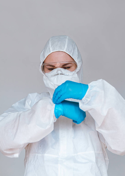 Női orvos védőöltözetet visel elleni küzdelemben coronavirus pandemic covid-2019. Védőruha, szemüveg, kesztyű, légzőkészülék. - Fotó, kép