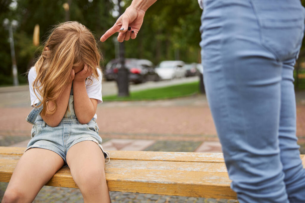 Irritada mãe jurando para sua filha enquanto passava o tempo ao ar livre
 - Foto, Imagem
