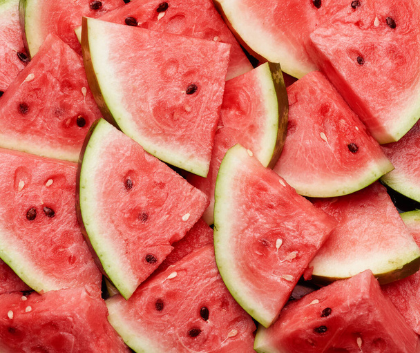 many sliced terrugol pieces of ripe red watermelon with brown seeds, fruit texture, full frame - 写真・画像