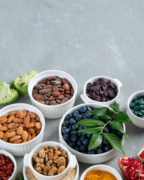 Bowls of various superfoods on grey background. Healthy organic food. Clean eating. View from above. - Foto, Imagem