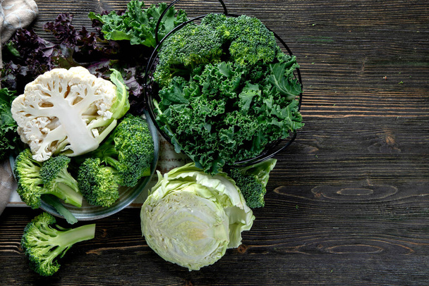 Assortment of fresh farm cabbages on wooden rustic table. Delicious fresh vegetables. The concept of healthy food. Top view, flat lay with copy space. - Photo, Image