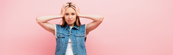 horizontal image of upset woman touching head while looking at camera isolated on pink - Photo, Image