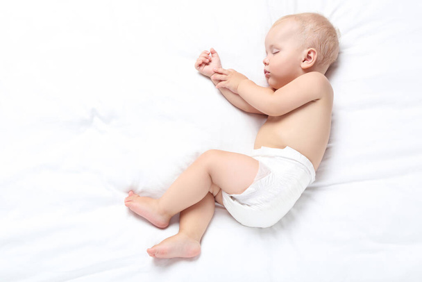 Beautiful little boy sleeping on bed at home - Foto, afbeelding