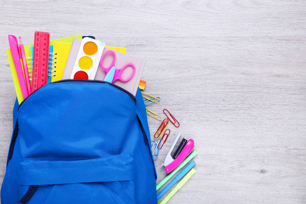 Backpack with school supplies on wooden table - Foto, immagini