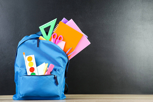 Backpack with school supplies on black background - Foto, Imagem
