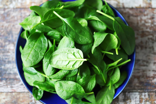 Fresh baby spinach. Washed spinach leaves on a blue plate. Diet concept. - Photo, Image