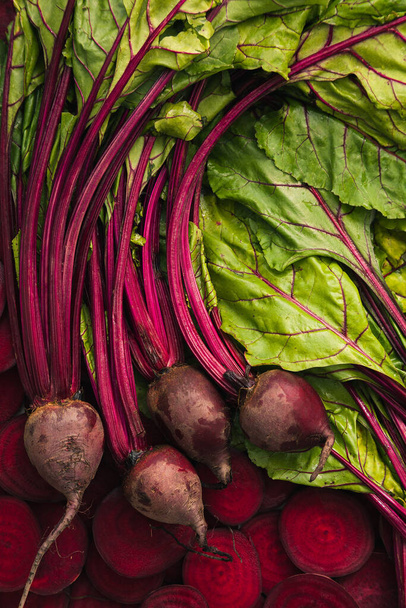 Top view of four fresh harvested beet, beetroot, beet slices, beet leaves for food background. - Photo, Image
