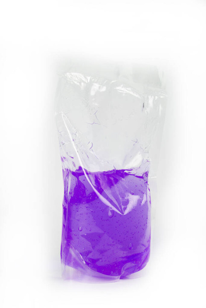 plastic bag with colored liquid on white background - Fotó, kép