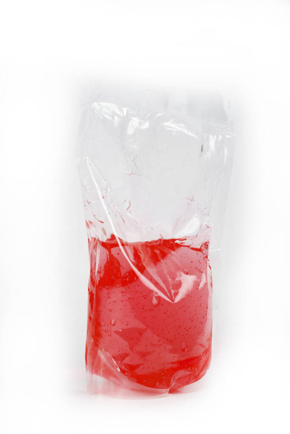 plastic zak met gekleurde vloeistof op witte achtergrond - Foto, afbeelding