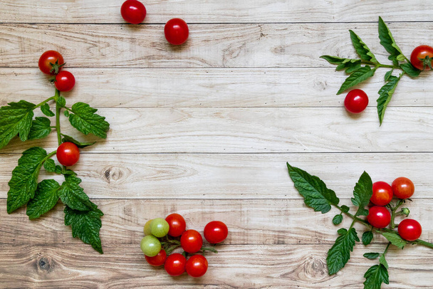 cherry tomatoes on wooden table background dark light leaves - Photo, image