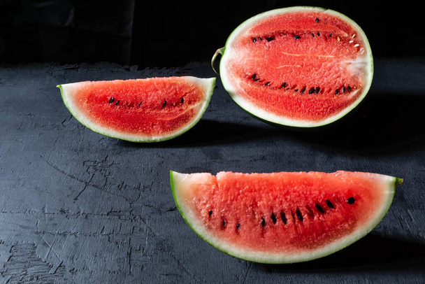 Melone fresco tagliato a metà su fondo nero. - Foto, immagini