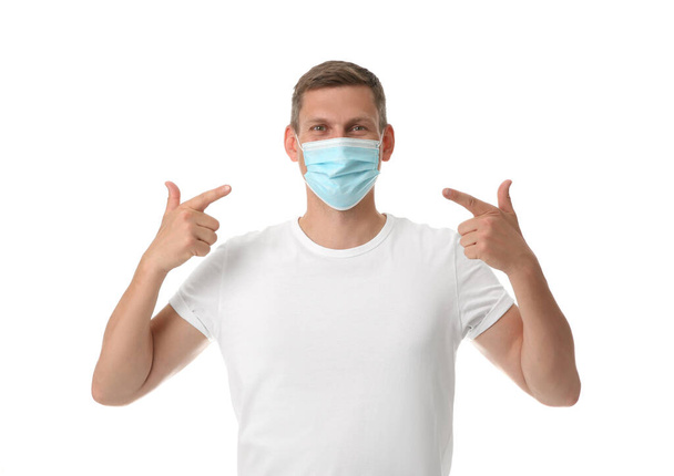 Male volunteer in mask on white background. Protective measures during coronavirus quarantine - Foto, Imagem