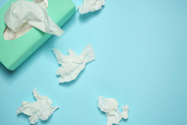 Used paper tissues and box on light blue background, flat lay. Space for text - Fotoğraf, Görsel