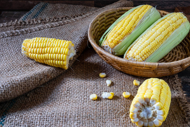 Fresh corn in basket on  on wooden table - 写真・画像