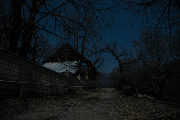 Täysikuu hiljaisen kylän yllä yöllä. Kaunis yömaisema vuoristokylässä kuunvalossa. Azerbaidzanin luonto. Pitkä valotusaika - Valokuva, kuva