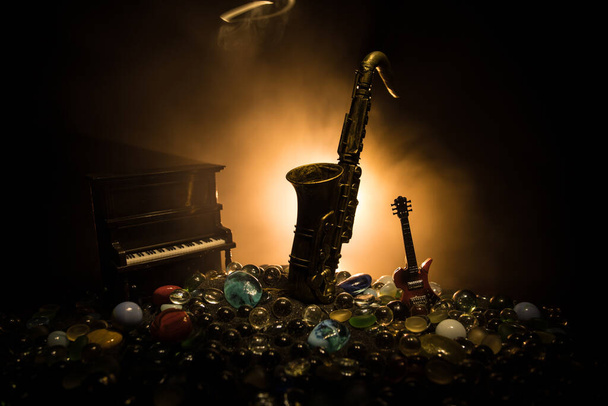 Концепция музыки. Саксофонный джазовый инструмент. Миниатюра из альто золота с цветным тонированным светом на туманном фоне. Музыкальные инструменты в малом свете. Селективный фокус - Фото, изображение