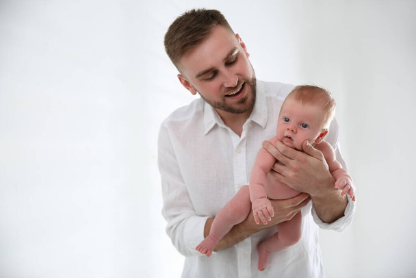 Father with his newborn son on light background - Foto, Bild