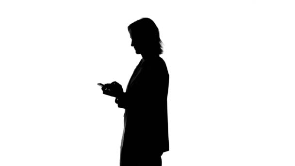 Video of womans silhouette talking on phone in suit jacket - Footage, Video