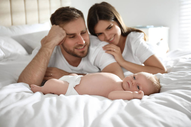 Happy couple with their newborn baby at home - Fotografie, Obrázek