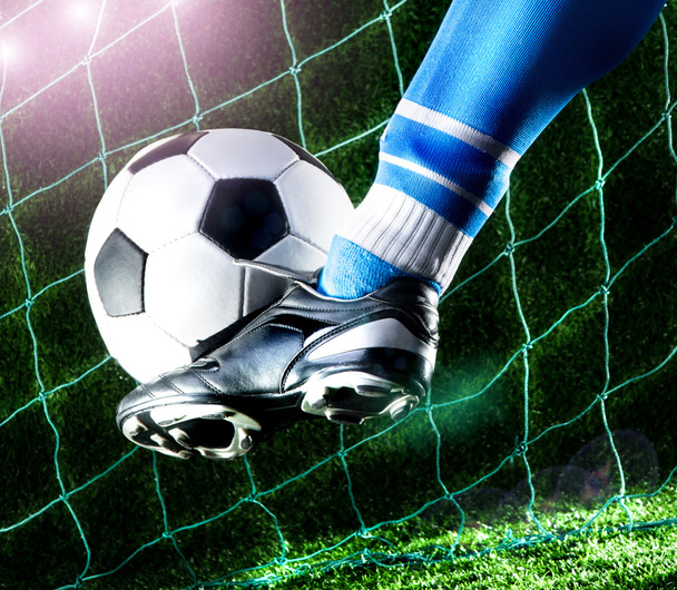 Foot kicking soccer ball - Foto, afbeelding