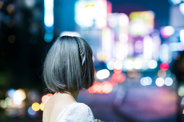 Mujer joven posando en el brillante paisaje urbano de Tokio por la noche - Foto, imagen