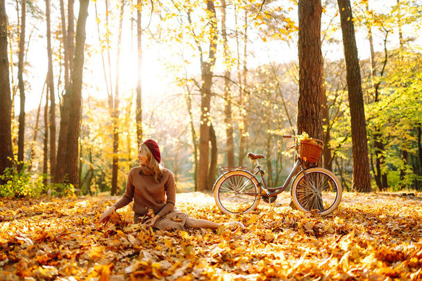 Beautiful Woman throws up autumn leaves and having fun  in autumn park. Relaxation, enjoying, solitude with nature. - Foto, Imagem