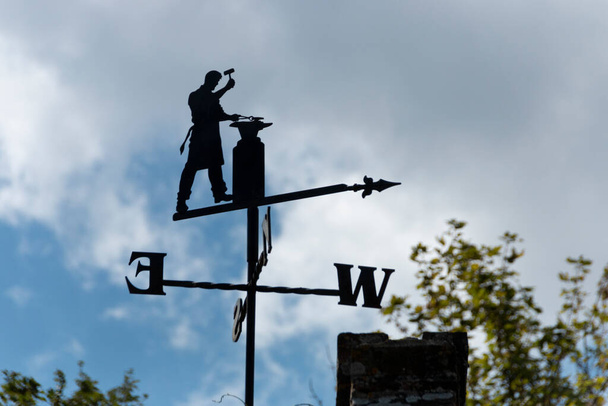 una vista de cerca de una brújula de viento de metal con un diseño herrero en  - Foto, Imagen