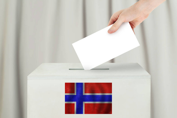 Норвезька концепція голосу. Виборча рука тримає бюлетень для голосування на виборчій дільниці - Фото, зображення