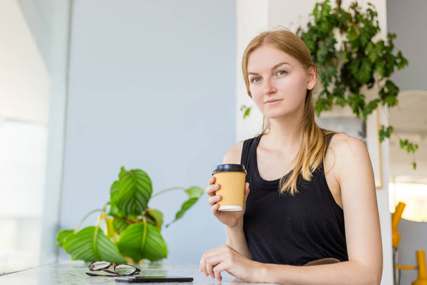 Kaunis nainen kahvilassa matkapuhelimella ja tekstiviestillä sosiaalisissa verkostoissa, Nainen freelancer juo kahvia. Ota pois käsite. - Valokuva, kuva