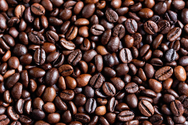 closeup of perfect Roasted coffee beans background. Food ingredients, top view, space for text. Soft selective focus. Cappuccino, aroma black caffeine drink ingredient for coffee beverage. Coffee Shop - Fotó, kép