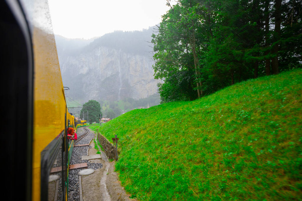 Dolina Lauterbrunnen, miejscowość Lauterbrunnen, wodospad Staubbach i mur Lauterbrunnen w Alpach Szwajcarskich, Szwajcaria. - Zdjęcie, obraz
