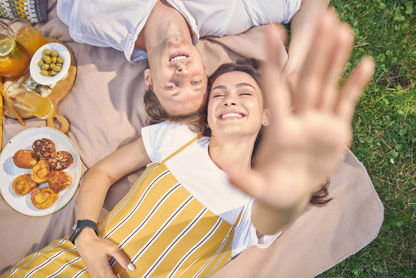 Glücklich lächelndes junges Paar auf dem grünen Park liegend - Foto, Bild