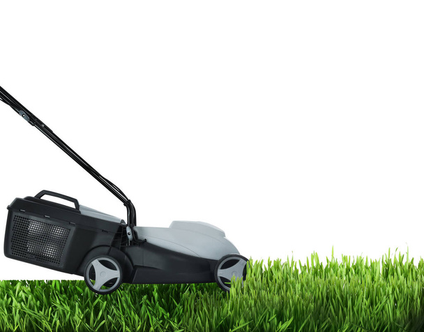 Modern garden lawn mower cutting green grass, white background - Fotó, kép