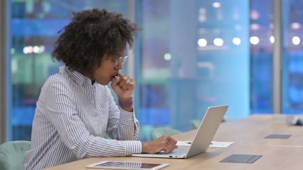 Malade femme d'affaires africaine avec ordinateur portable tousse dans le bureau  - Séquence, vidéo
