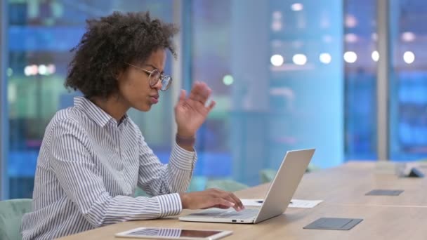 Femme d'affaires africaine stressée avec ordinateur portable ayant mal à la tête au bureau  - Séquence, vidéo