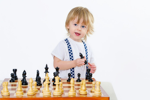 Portrait of a cheerful kid playing chess - Фото, изображение