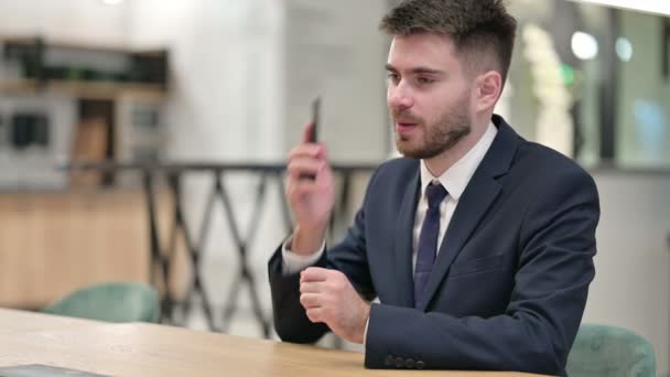 Joven empresario alegre hablando en Smartphone en la oficina - Imágenes, Vídeo