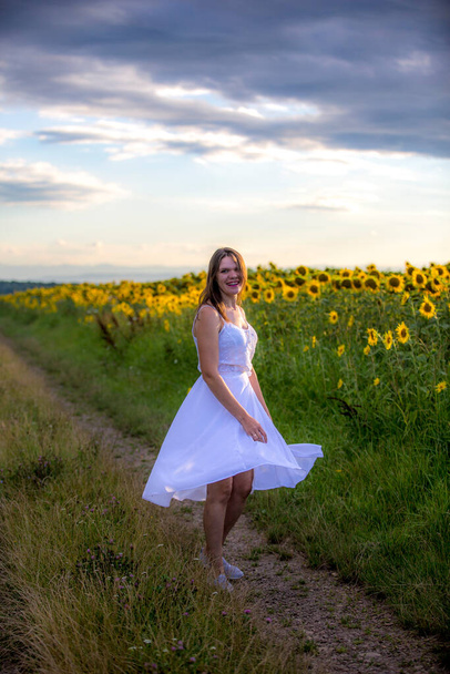 Beautiful girl in the field of sonflowers - Φωτογραφία, εικόνα